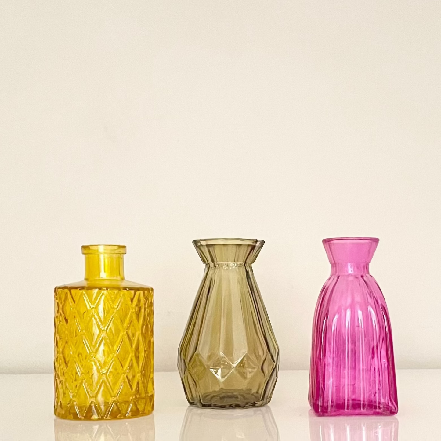 Artisanal colourful glass bottles on a white background.
