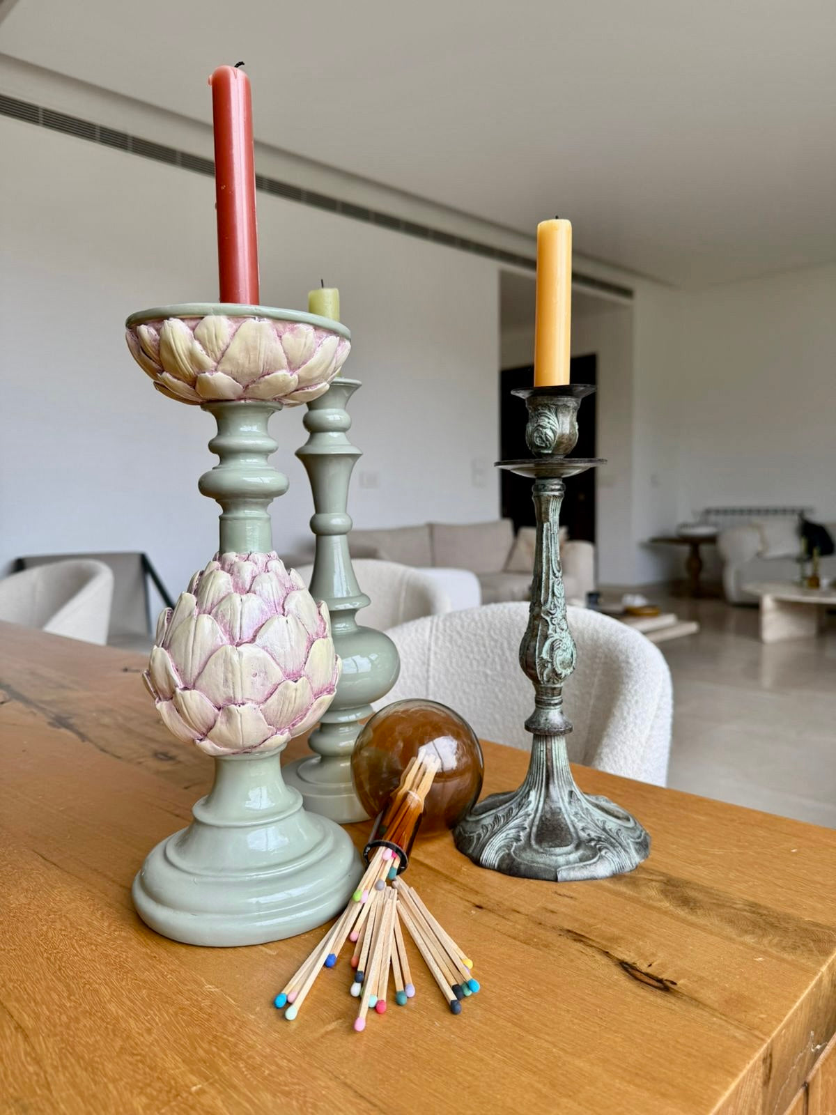 9.8 cm coloured tipped matches next to decorative candles on a wooden table in a living room setting.