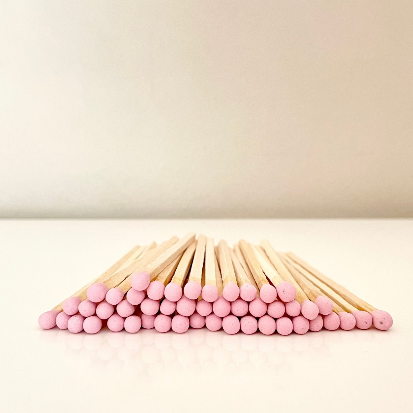 9.8 cm dusky pink matches on a white surface.