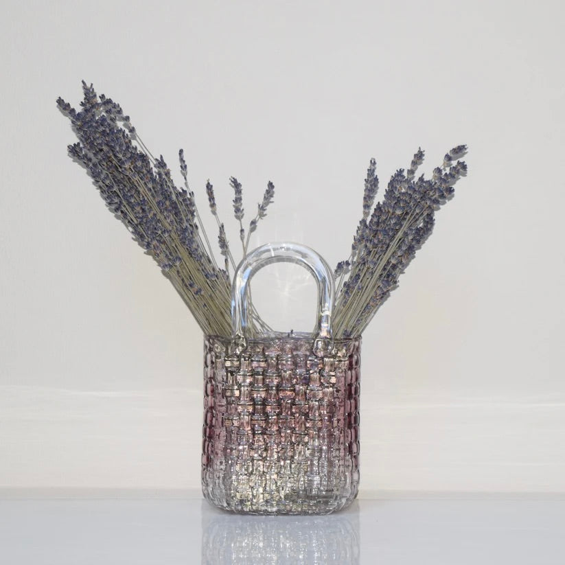 Woven purple glass vase with dried lavender on a white background.