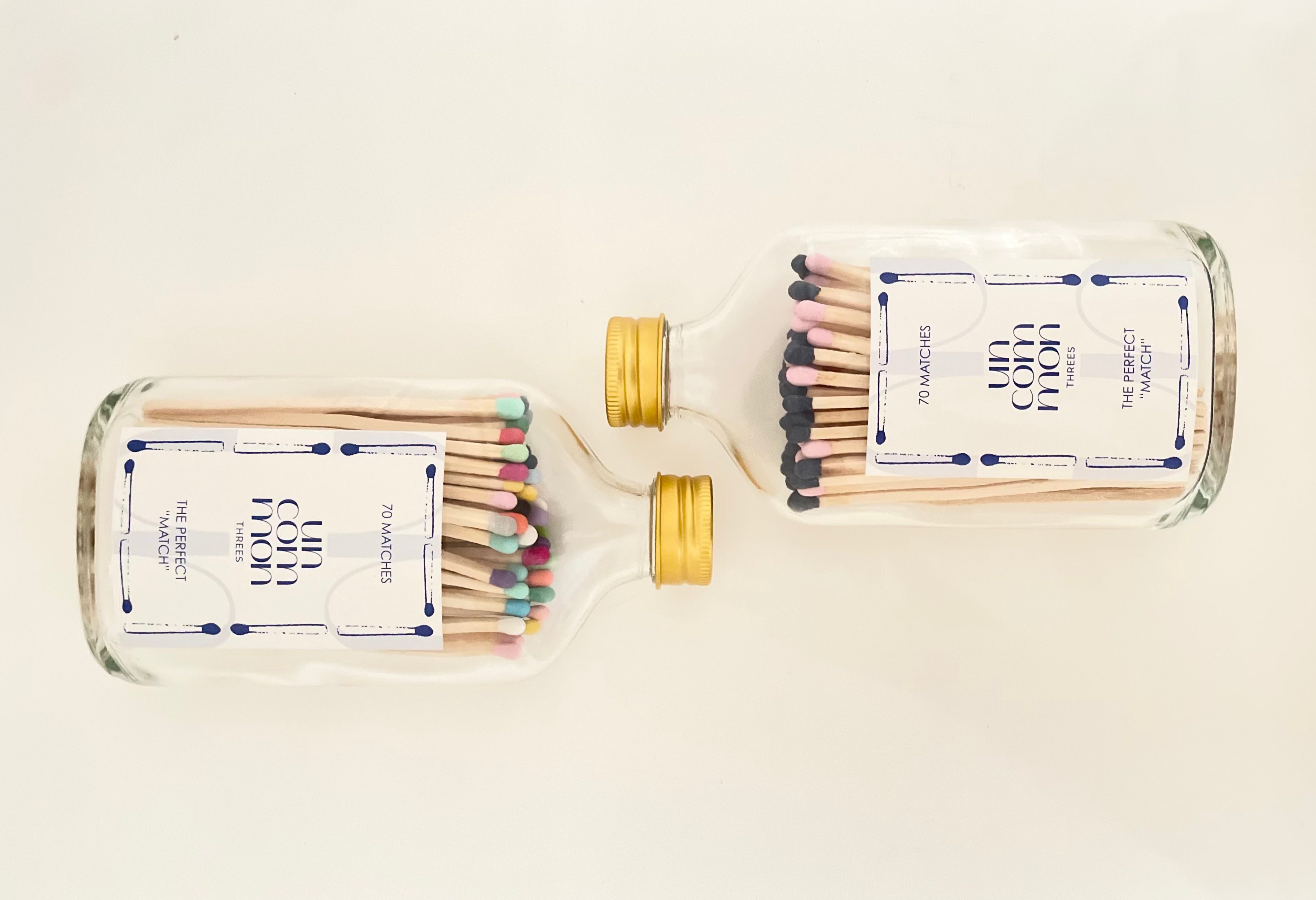 Two glass bottles filled with 9.8 cm vibrant matches on a white background.