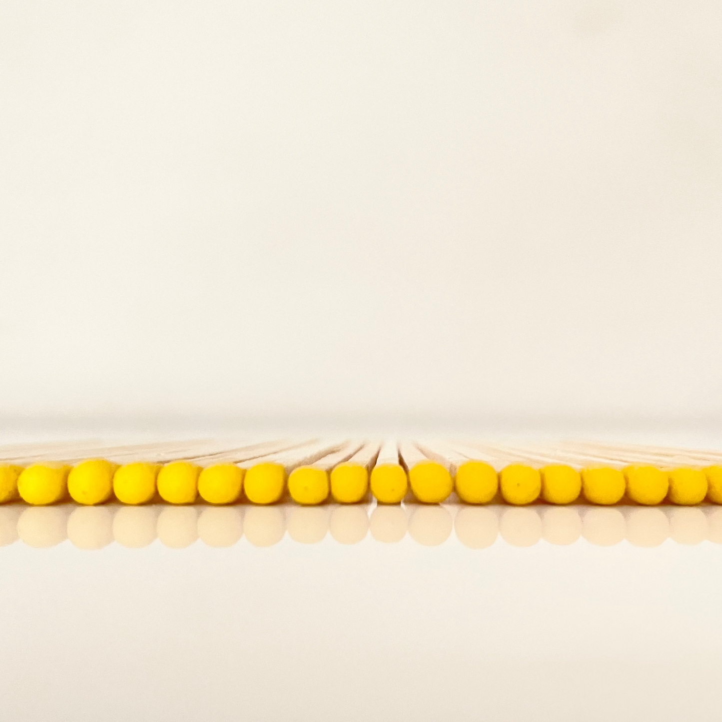 9.8 cm yellow matches on white surface.