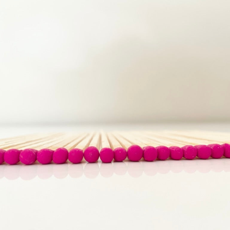 9.8 cm hot pink matches on white surface.