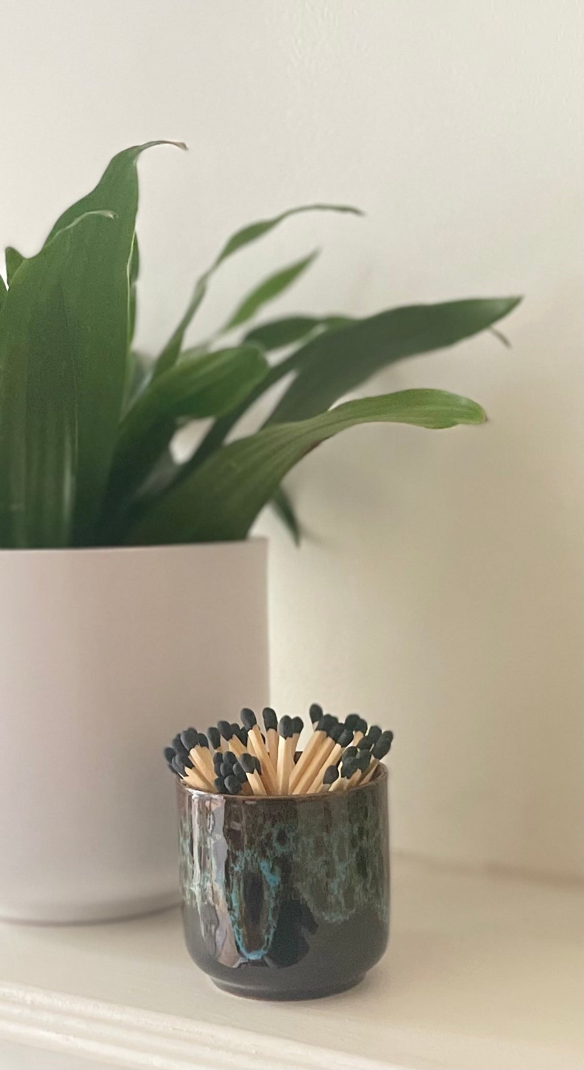 Blue glazed match holder on white surface.