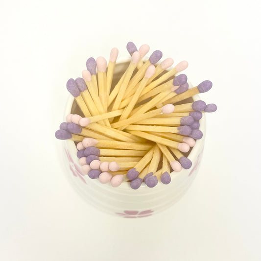 Refill Matches in a white ceramic mach holder with flowers.