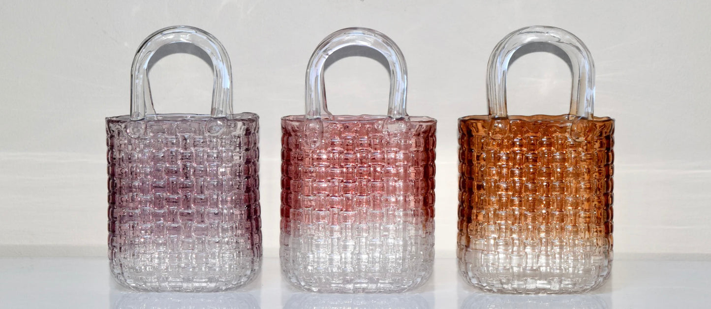 Decorative glass vases with woven designs in purple, pink, and amber on a white background.