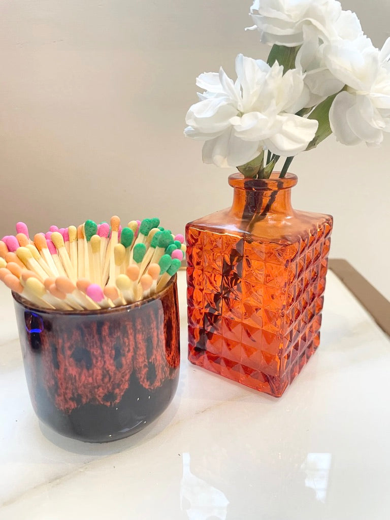Orange glass vase (F) with textured surface on a white background.