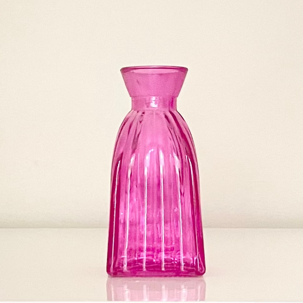 Pink glass vase (C) with textured surface on a white background.