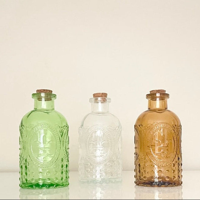 Vintage glass vases with corks, available in green, clear and amber. These multipurpose jars are perfect for holding matches, storing small items, or to display fresh or dried flowers.