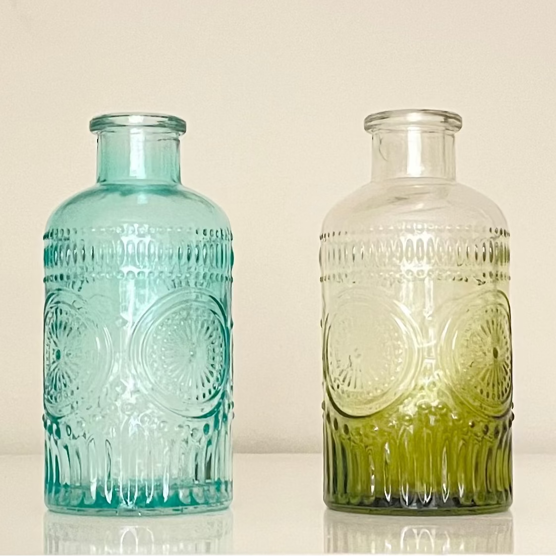A beautiful vintage glass vase available in blue and green, made from eco-friendly, BPA-free glass. Perfect for table decor, home decor, or as a unique addition to any office space.