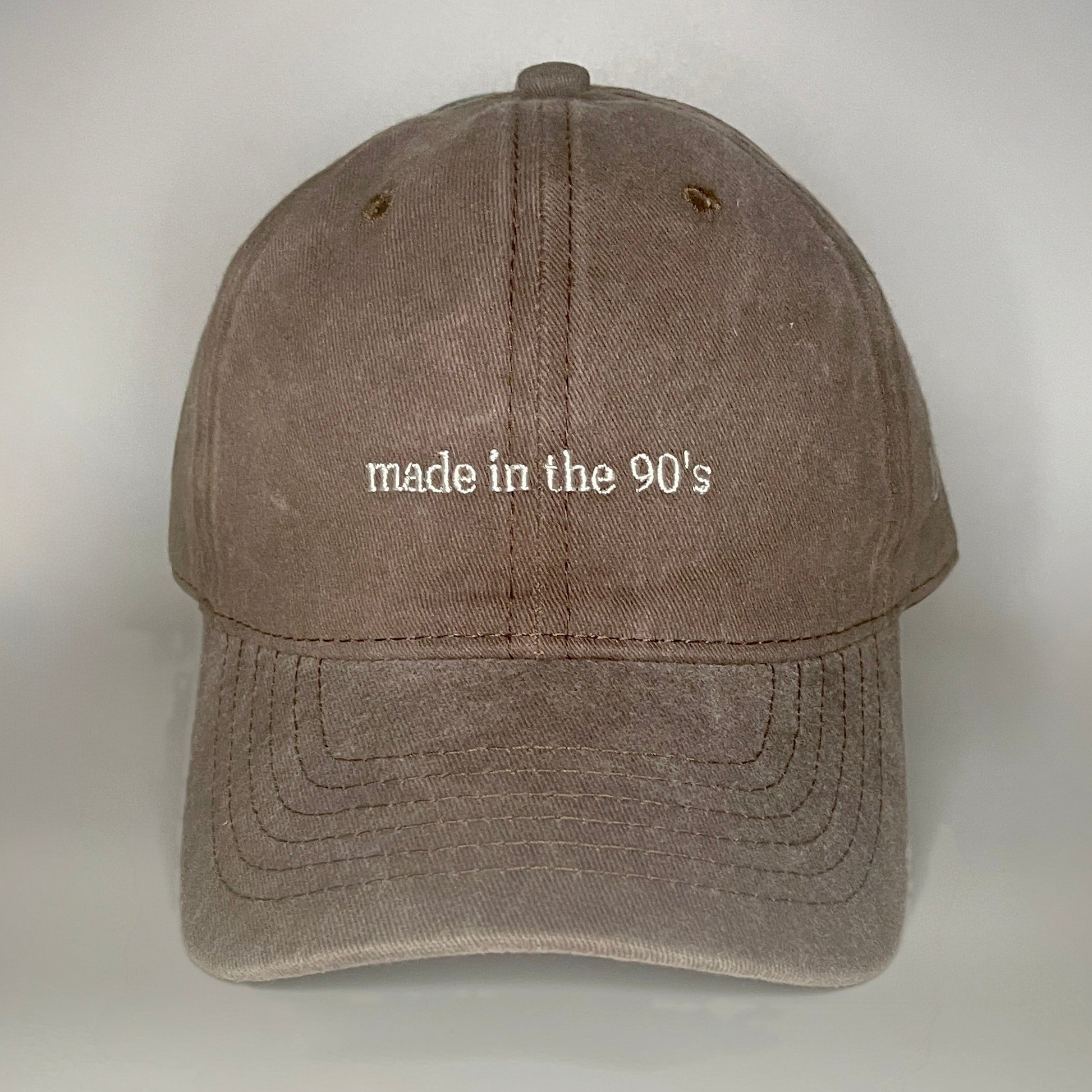 100% Brown washed cotton cap with 'made in the 90's' embroidery in white. 