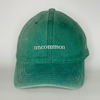100% Green washed cotton cap with 'uncommon' white embroidery. 