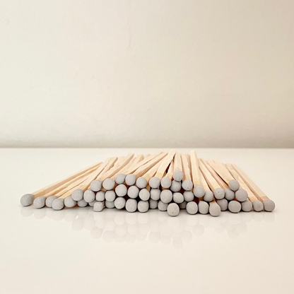9.8 cm grey matches on a white surface. 