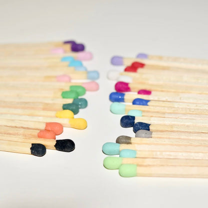 9.8 cm coloured matches on a white surface. 