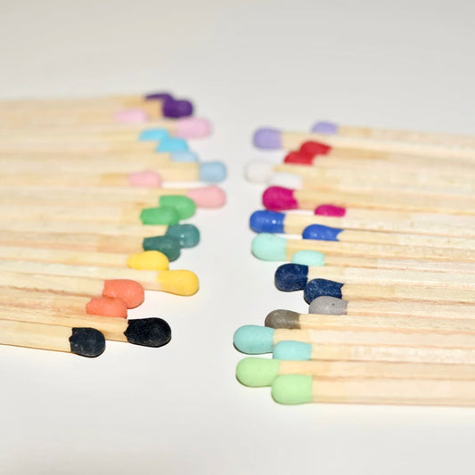9.8 cm coloured matches on a white surface. 
