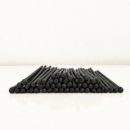 7.5 cm all black safety matches on a white surface.