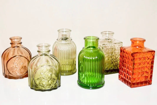 Artisanal colourful glass bottles on a white background.
