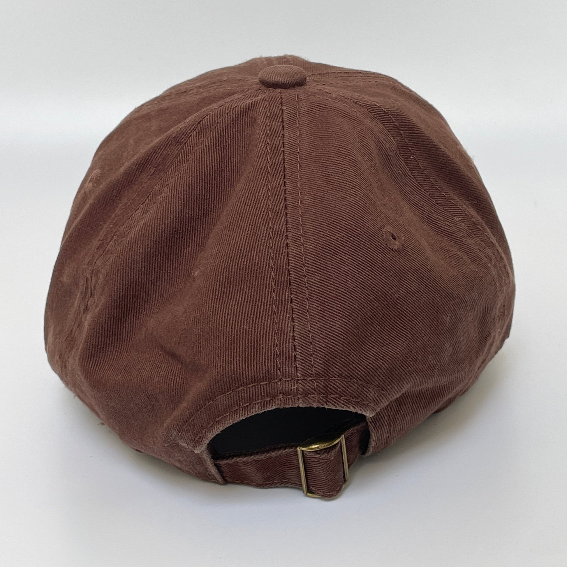 Brown cap with metal clasp on white background. 