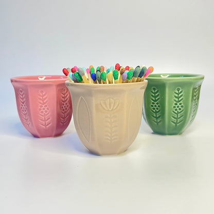 pink, beige and green match holder/coffee cup with flower design filled with coloured safety matches.