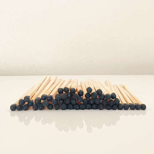 4.8 cm black matches on a white surface. 