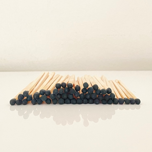 7.5 cm black matches on a white surface. 