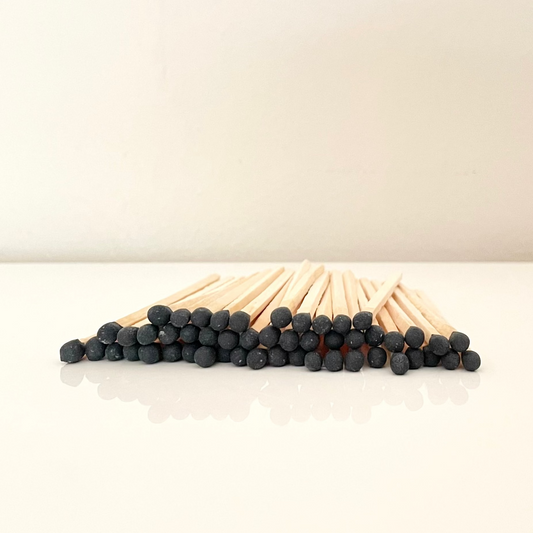 9.8 cm black matches on a white surface. 