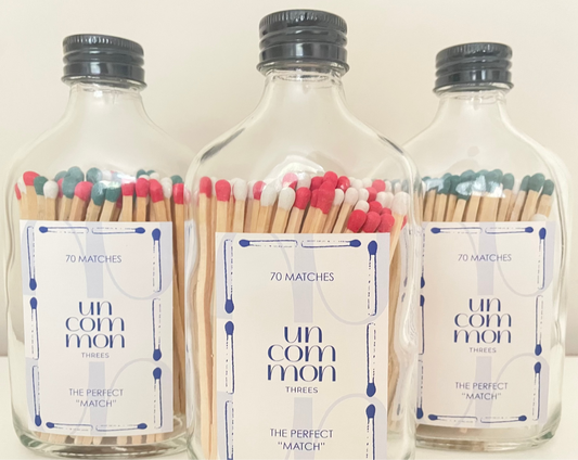 Black lid glass bottles filled with 9.8 cm red, dark green and white matches on a white background.