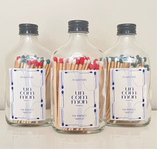 Black lid glass bottles filled with 9.8 cm red, dark green and white matches on a white background.