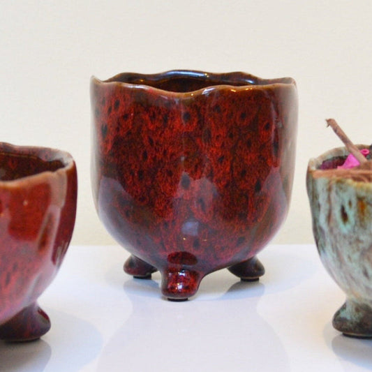  Glazed ceramic pot in bordeaux on a white background. 