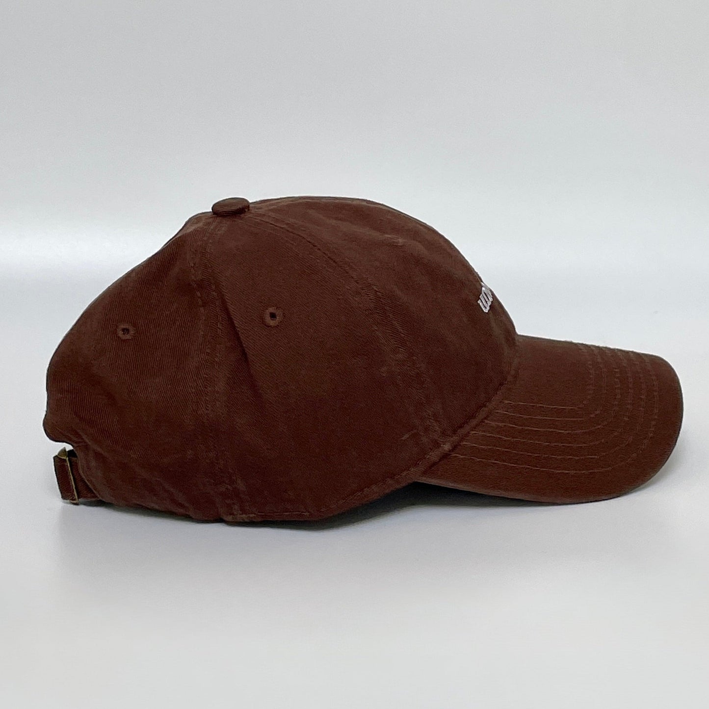 100% Pink washed cotton cap with 'unbothered' white embroidery with side emblem 'un'. 