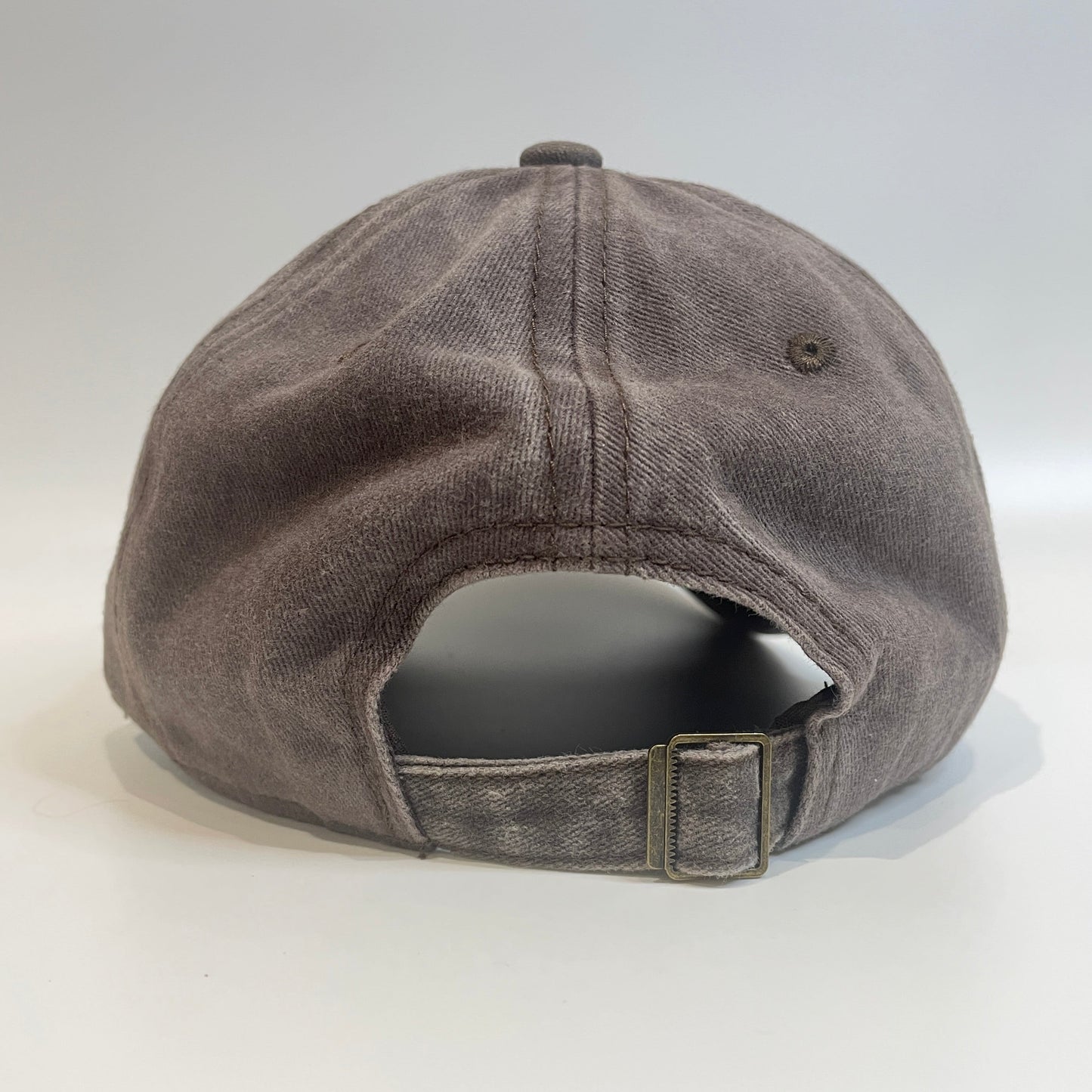 Brown cap with metal clasp on white background. 