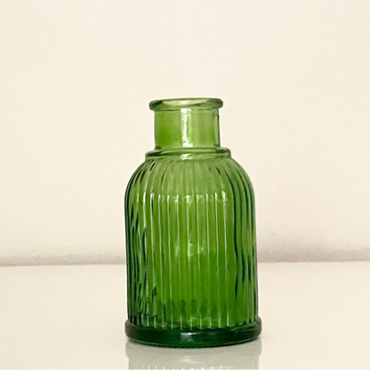 Green glass vase (D) with textured surface on a white background.