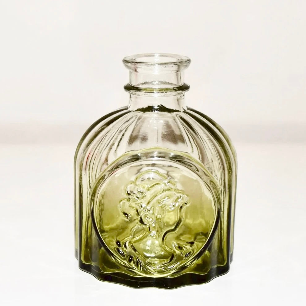 Green glass vase (B) with textured surface on a white background.