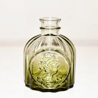 Green glass vase (B) with textured surface on a white background.