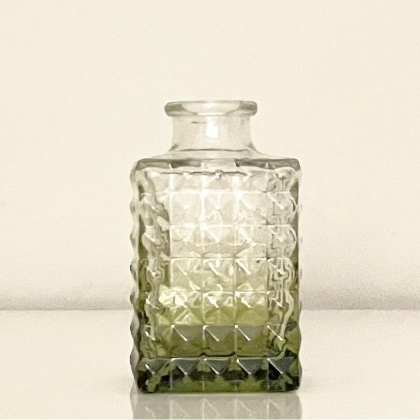 Green glass vase (E) with textured surface on a white background.