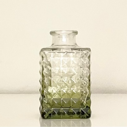 Green glass vase (E) with textured surface on a white background.