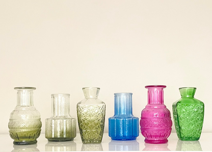Colourful artisanal glass vases on a white background.