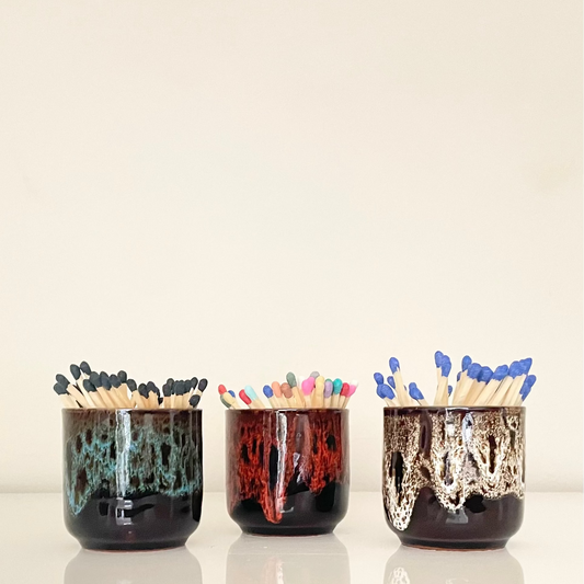 Set of six ceramic match holders/planters with unique glaze patterns on a light background.