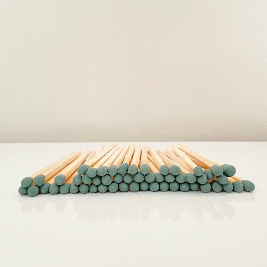 4.8 cm forest green matches on a white surface. 