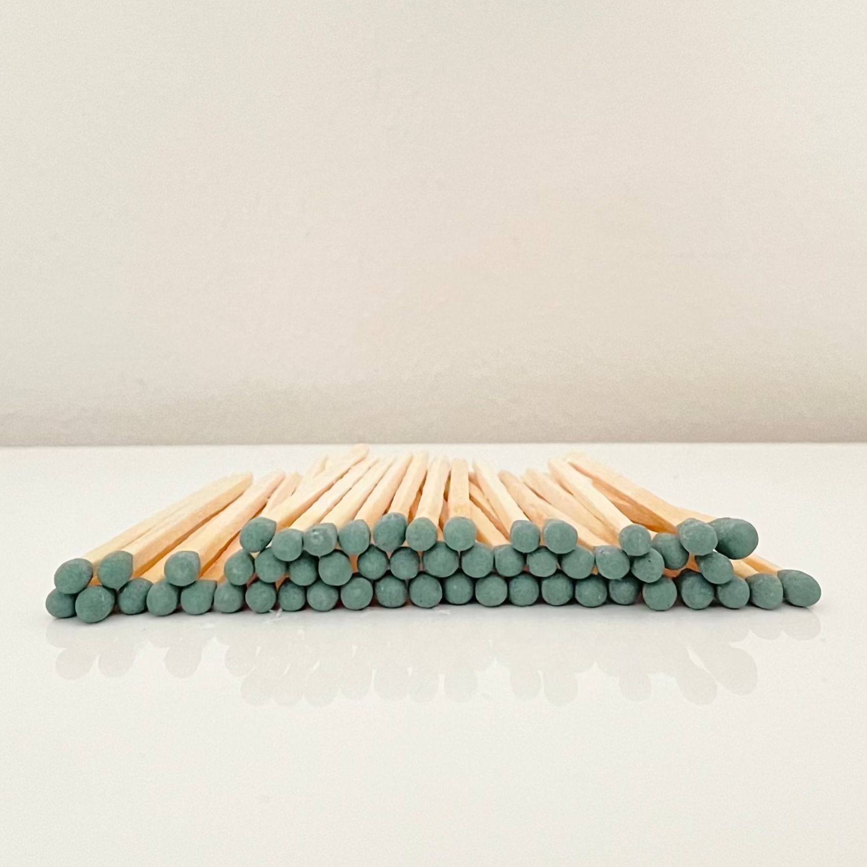 7.5 cm forest green matches on a white surface. 