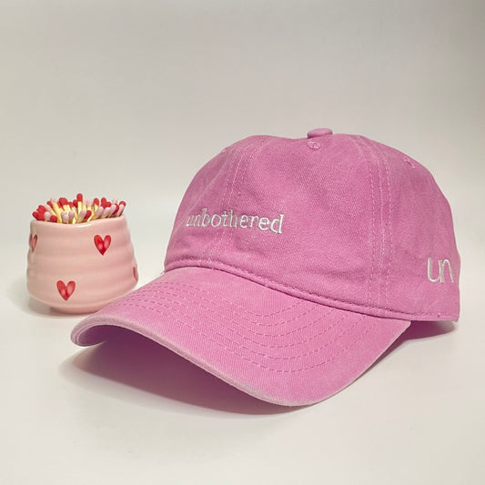 The gift set includes a pink 100% cotton "unbothered" embroidered hat with a pink heart match holder/coffee cup and 50 7.5cm matches. 
