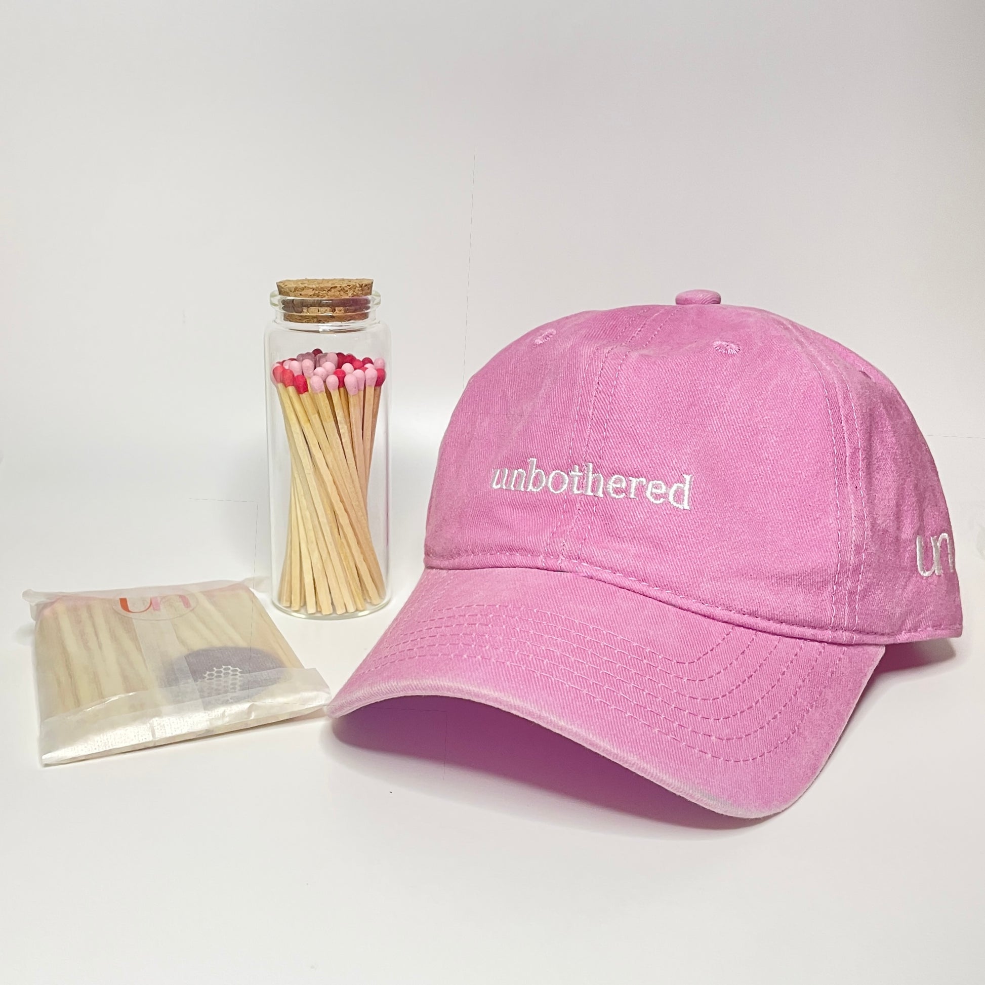 The gift set includes pink 100% cotton "unbothered" embroidered hat with a test tube match bottle and 9.8 cm matches. 