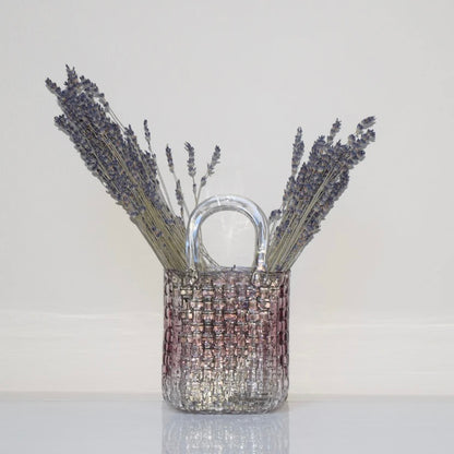Woven purple glass vase with dried lavender on a white background.