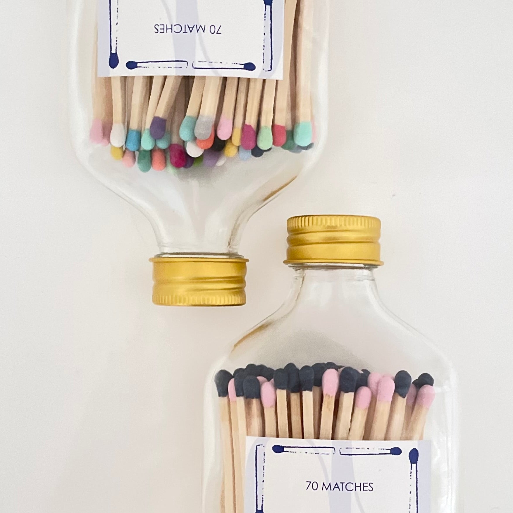 Two glass bottles filled with 9.8 cm vibrant long safety matches on a white background.
