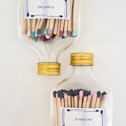 Two glass bottles filled with 9.8 cm vibrant long safety matches on a white background.