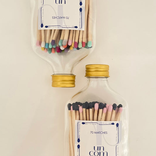 Two glass bottles filled with 9.8 cm colourful matches on a white background.
