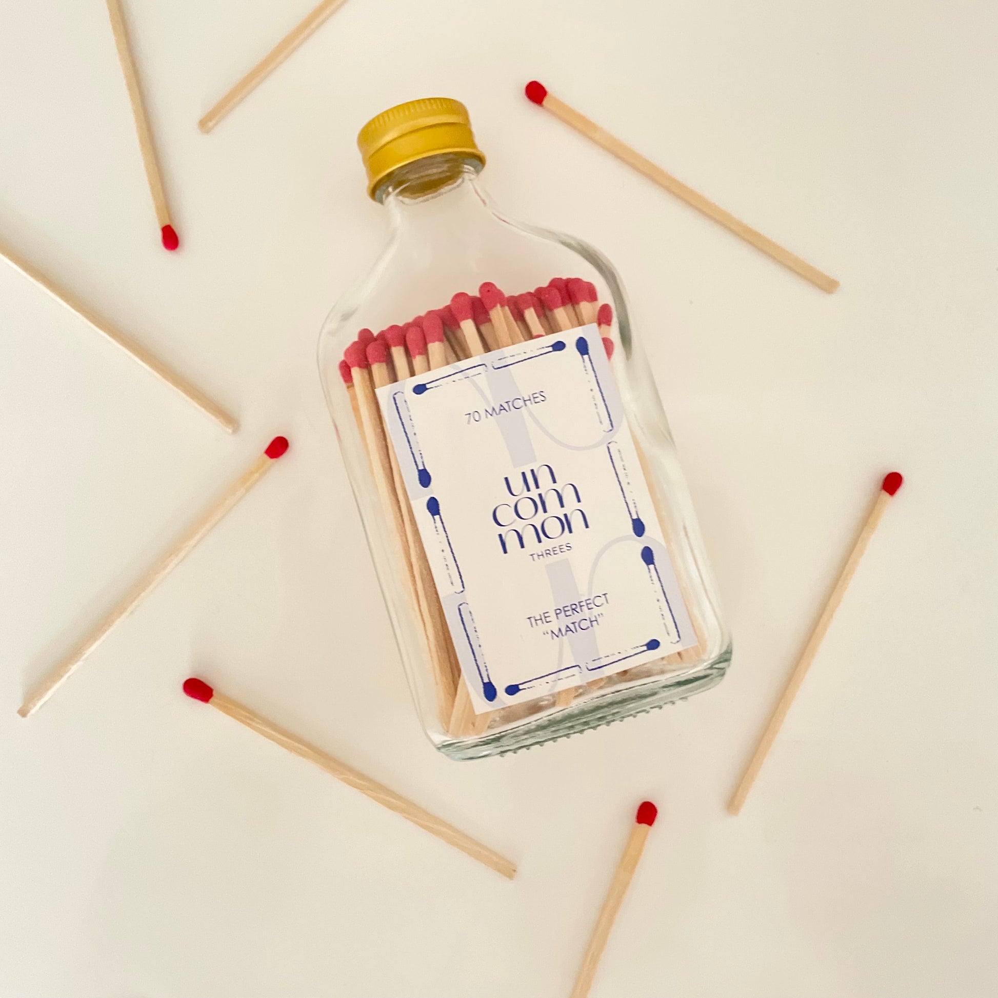 Clear glass bottle filled with dark blue 9.8 cm matches.
