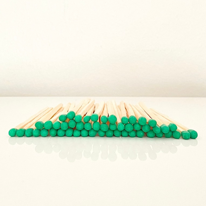 4.8 cm green matches on a white surface. 