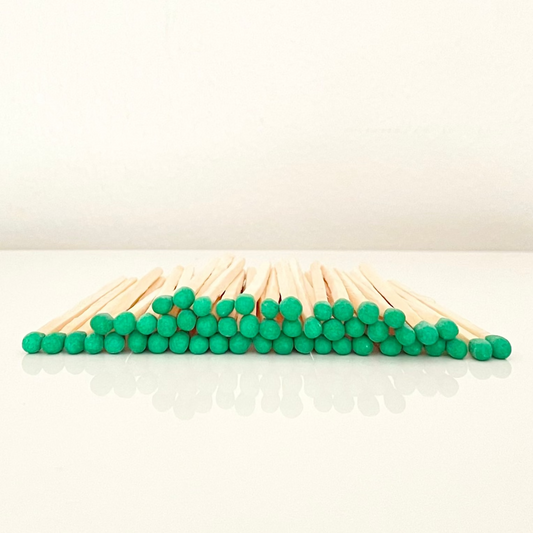 4.8 cm green matches on a white surface. 