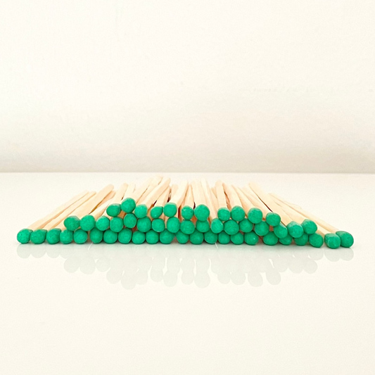 7.5 cm green matches on a white surface. 